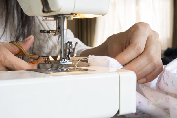 缝纫机的特写图像。双手在缝纫机上工作图片下载