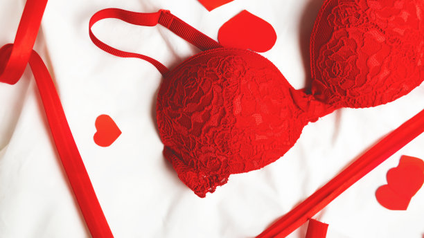 性感优雅的蕾丝红色内衣在白色的床上的背景。时尚，爱情，性，情人节概念。图片下载