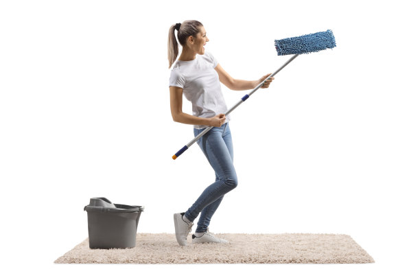 年轻女子在地毯上拿着拖把跳舞图片下载