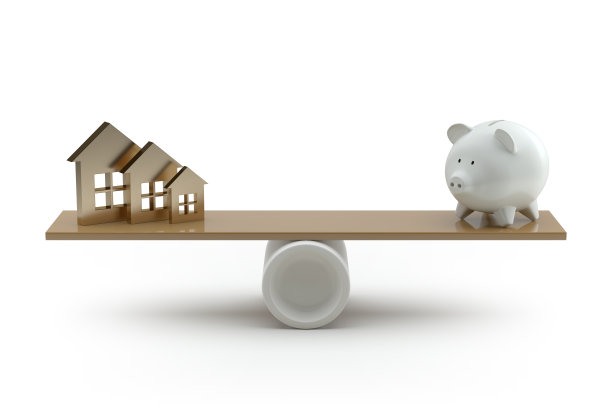 跷跷板上的房子与小猪储蓄罐在白色背景上的平衡图片下载