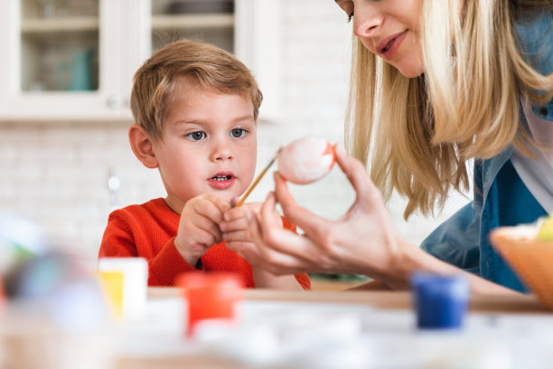 快乐的白人小男孩和他妈妈在画复活节彩蛋素材图片