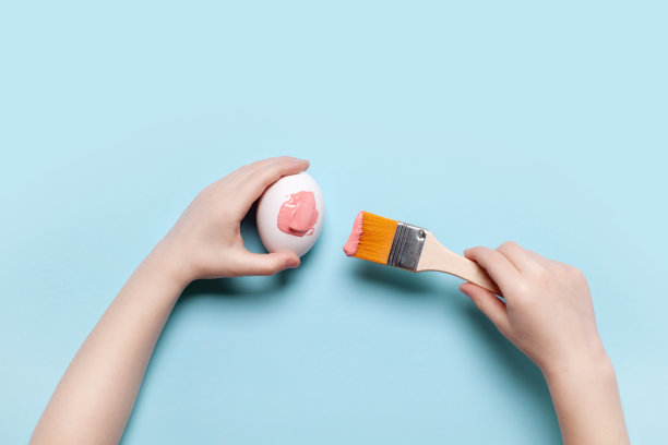 那孩子用粉红色颜料画复活节彩蛋图片下载