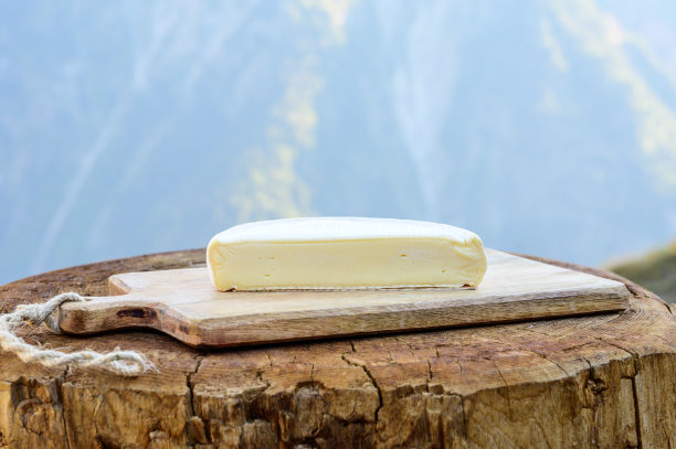 奶酪系列，在萨伏伊地区的户外供应法式萨伏伊奶酪，背景是阿尔卑斯山脉的山峰图片下载