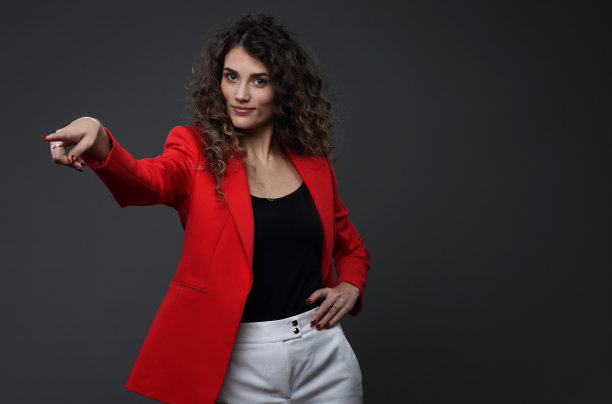 灰色背景下穿着红夹克的漂亮女孩的肖像图片下载