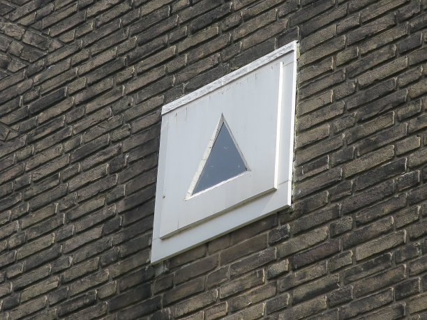 褐色砖墙上的三角形小窗图片下载