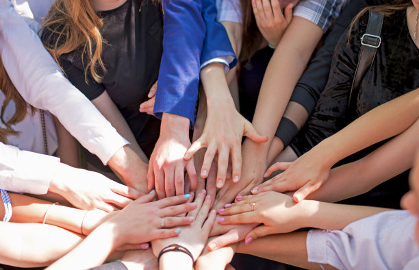 一群孩子把手放在一起。团队合作伙伴关系概念图片下载