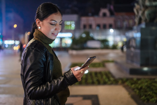一个年轻的女人在晚上敲电话。库存图片图片下载