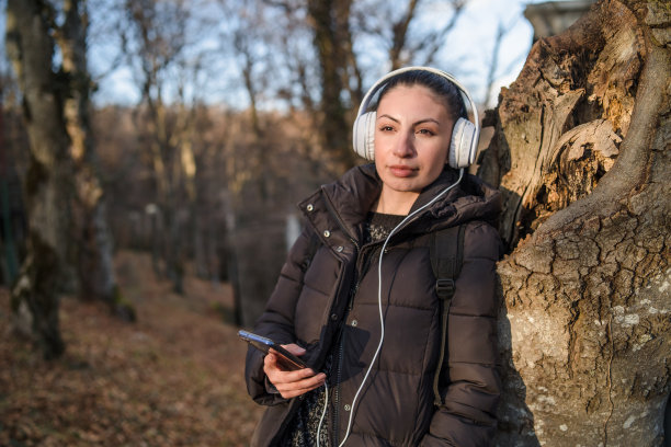 一个年轻女子用电话听音乐。库存图片图片下载