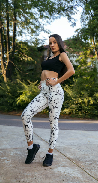 年轻的黑发健身模特在户外瑜伽裤摆姿势图片下载