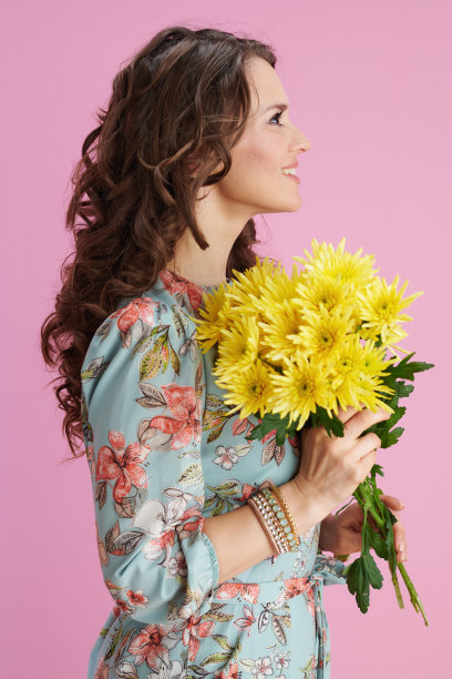 微笑时髦的女人在粉红色的花裙子图片下载