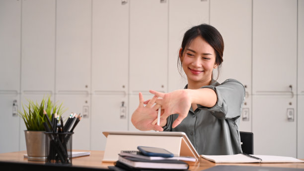 疲惫的女办公室职员放松和伸展她的身体在工作场所。图片下载