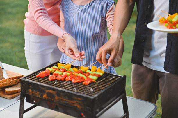 在烧烤的时候，人们正在互相帮助。图片下载