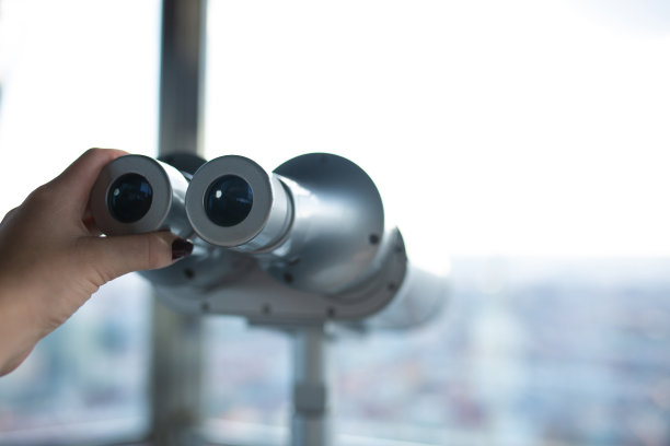 女性手拿望远镜看着从天文台拍摄的城市全景背景图片下载