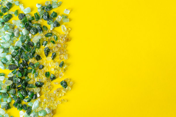 黄色背景上的绿色宝石。明亮的背景插入文本。图片下载