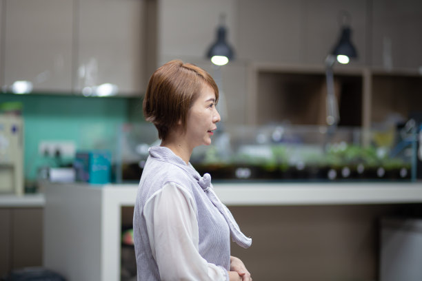 一位亚洲华人商人在办公大楼里向外看图片下载