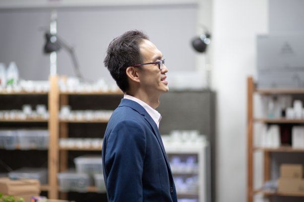 一位亚洲华人商人在办公大楼里向外看图片下载