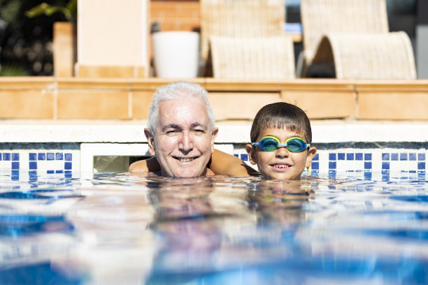 夏天爷爷和孙子在游泳池里玩图片下载