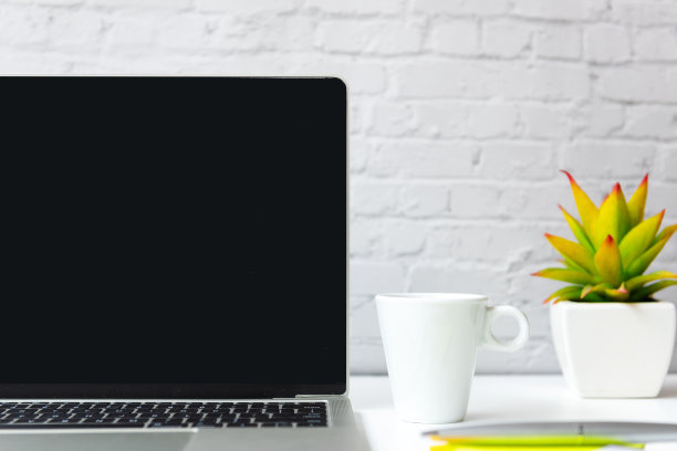 关爱健康生活办公室。喝热咖啡白色杯放松，休息与笔记本电脑背景。生活方式健康概念图片下载