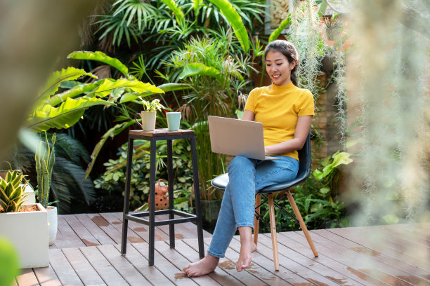 年轻人在家里用笔记本电脑工作，在家里的花园里喝咖啡图片下载