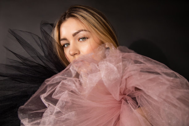 工作室拍摄美丽的年轻女子化妆和网状晚礼服，在黑色背景下摆姿势，复制空间，广告香水的美丽概念，透过纺织品图片下载