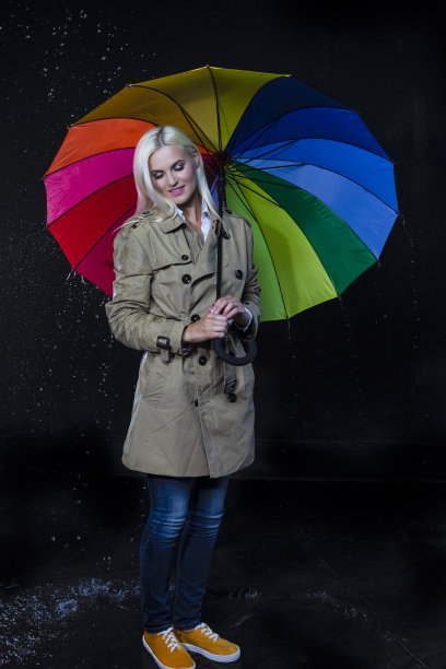 全长Portarit正面白种人金发女性摆姿势与彩色伞下的雨滴。垂直组成图片下载