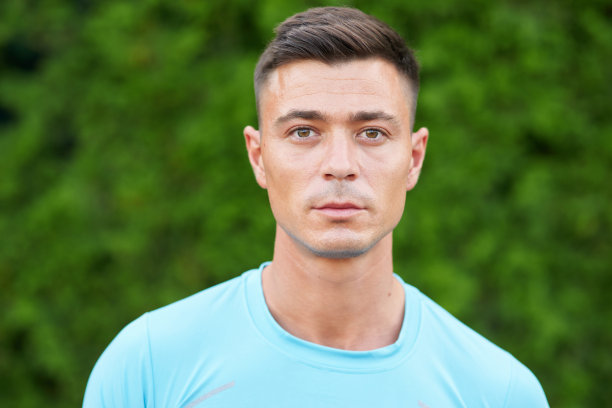 专业的周期计。好看的年轻和健康的男人的肖像在运动服看着相机，摆姿势在户外的自然图片下载