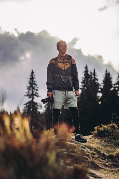 在吉泽拉山日落时，一个新手摄影师穿着运动服的自拍。这名男子手里拿着相机，看起来下定决心要做正确的事图片下载