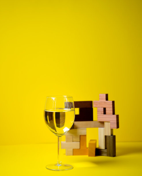 一杯白葡萄酒，在一个彩色的背景与抽象的设计，一个非标准的广告方法，品牌排他性，现代风格和苛刻的客户。旗帜,酒精饮料图片下载
