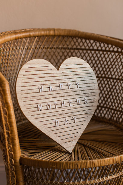 在藤椅上用一个心形的牌子写着“母亲节快乐”图片下载