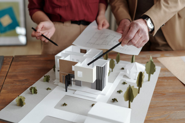 年轻的女建筑师和她成熟的男同事指着新房子的模型图片下载