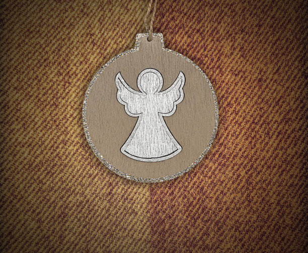圆天使吊坠在棕色羊绒纺织背景图片下载