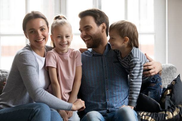 快乐的父母和在沙发上放松的学龄前孩子的肖像图片下载