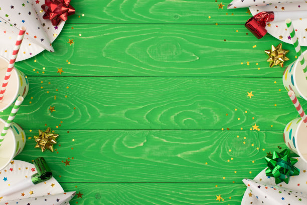 生日聚会合成的顶视图照片缎带星星管子，草帽，亮片，波尔卡圆点，纸杯和盘子在孤立的绿色木制桌子背景与copyspace图片下载