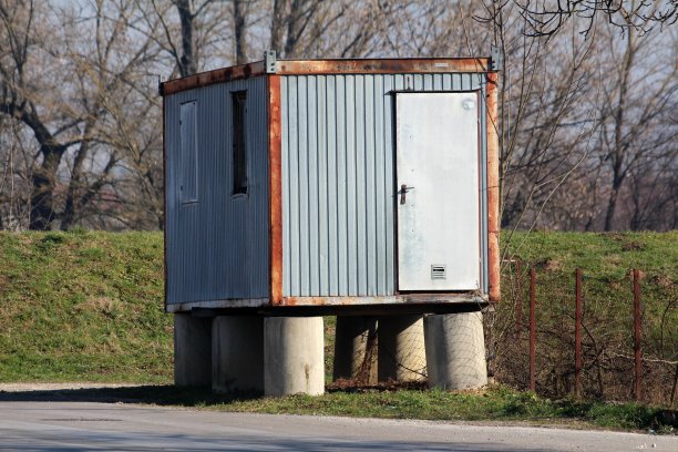 旧的破旧的部分生锈的金属集装箱改造为生活区，在六个混凝土支柱基础上图片下载