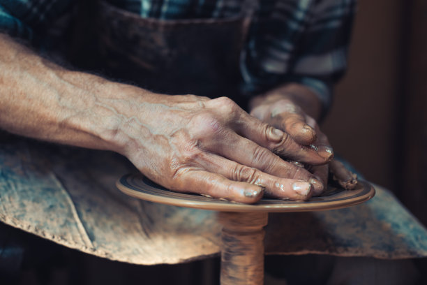 在陶瓷车间。大师的手很漂亮，在花盆轮上做豌豆。放置你的文本。图片下载