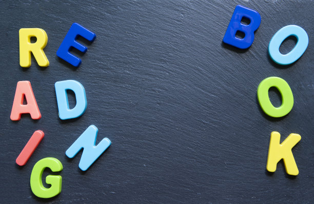 文字阅读的书。以黑色石头为背景的彩色字母框架。赢富数据。Copyspace。概念回到学校。图片下载