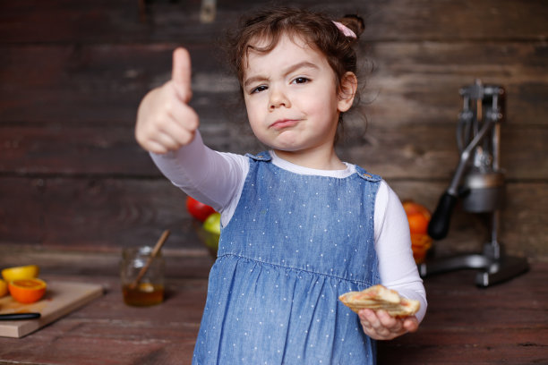 一个漂亮的白人小女孩在吃热烤三明治。库存图片图片下载