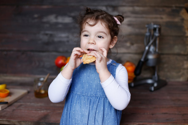 一个漂亮的白人小女孩在吃热烤三明治。库存图片图片下载