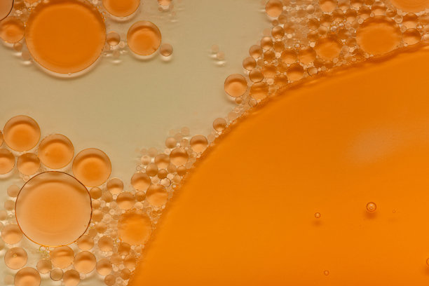 明亮的液体橙色凝胶或油精华血清乳剂泡沫白色和多色孤立背景图片下载