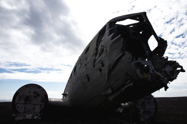 黑色海滩上一架破碎飞机的剪影图片下载