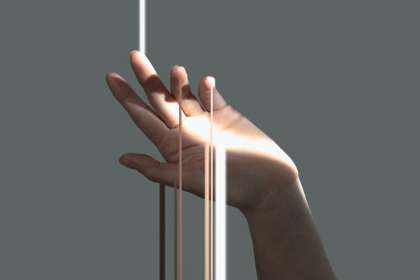 光线通过精致的女性手孤立在灰色的背景。图片下载