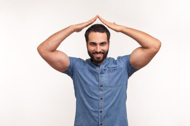 正面微笑的男人手举过头顶展示屋顶，房子标志，保险公司员工保证购买房产安全图片下载