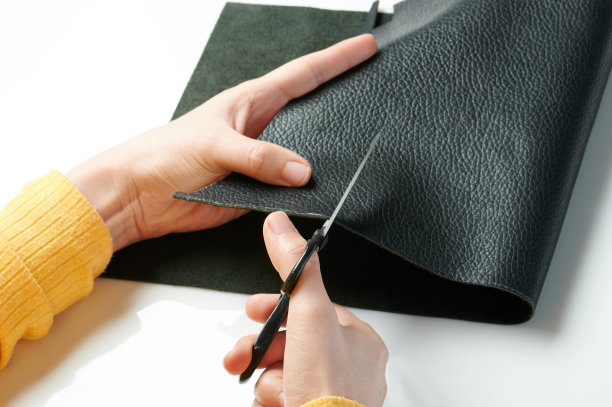裁缝用手裁一块皮革图片下载