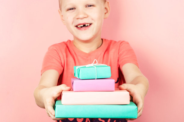 拿着四个礼品盒的男孩。图片下载