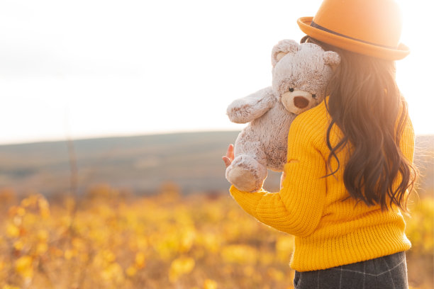 在草地上拿着玩具的无名小孩图片下载