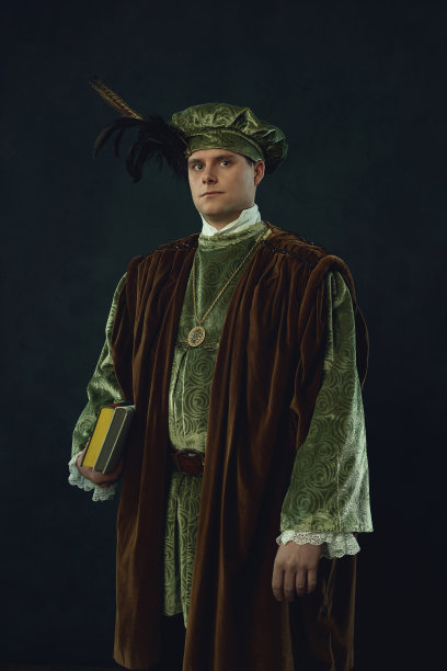 一个文艺复兴时期的人拿着一本书站在一堵黑暗的墙前。图片下载