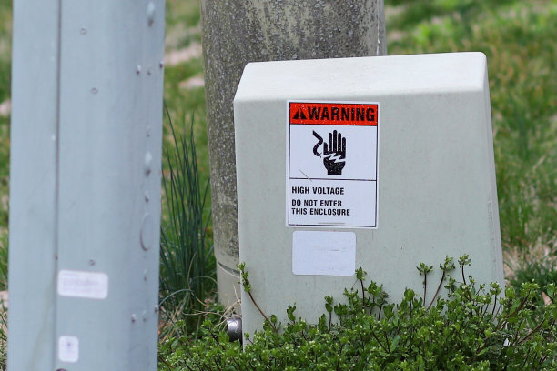 在前院，一个安装在电动变压器上的高压警告标志图片下载