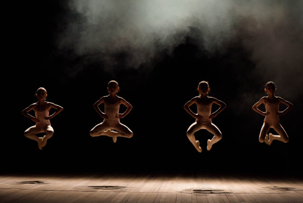 一群小型芭蕾舞者在灯光和烟雾中在舞台上排练图片下载