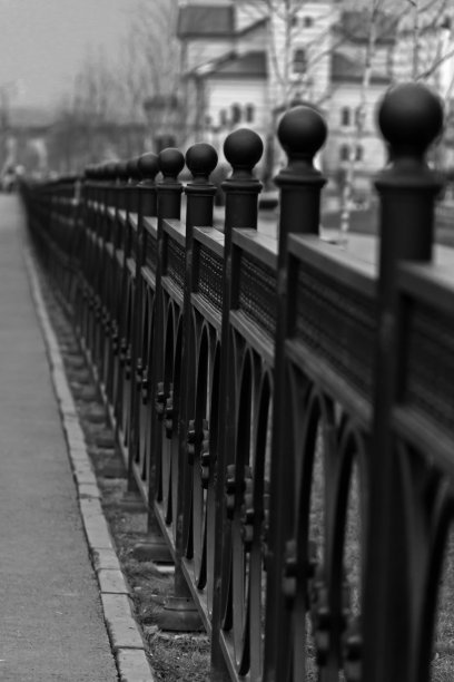 延伸到远处的金属装饰篱笆。图片下载