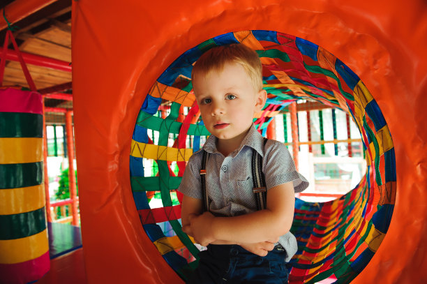 男孩在操场上玩耍，在儿童的迷宫里。孩子们的迷宫。图片下载